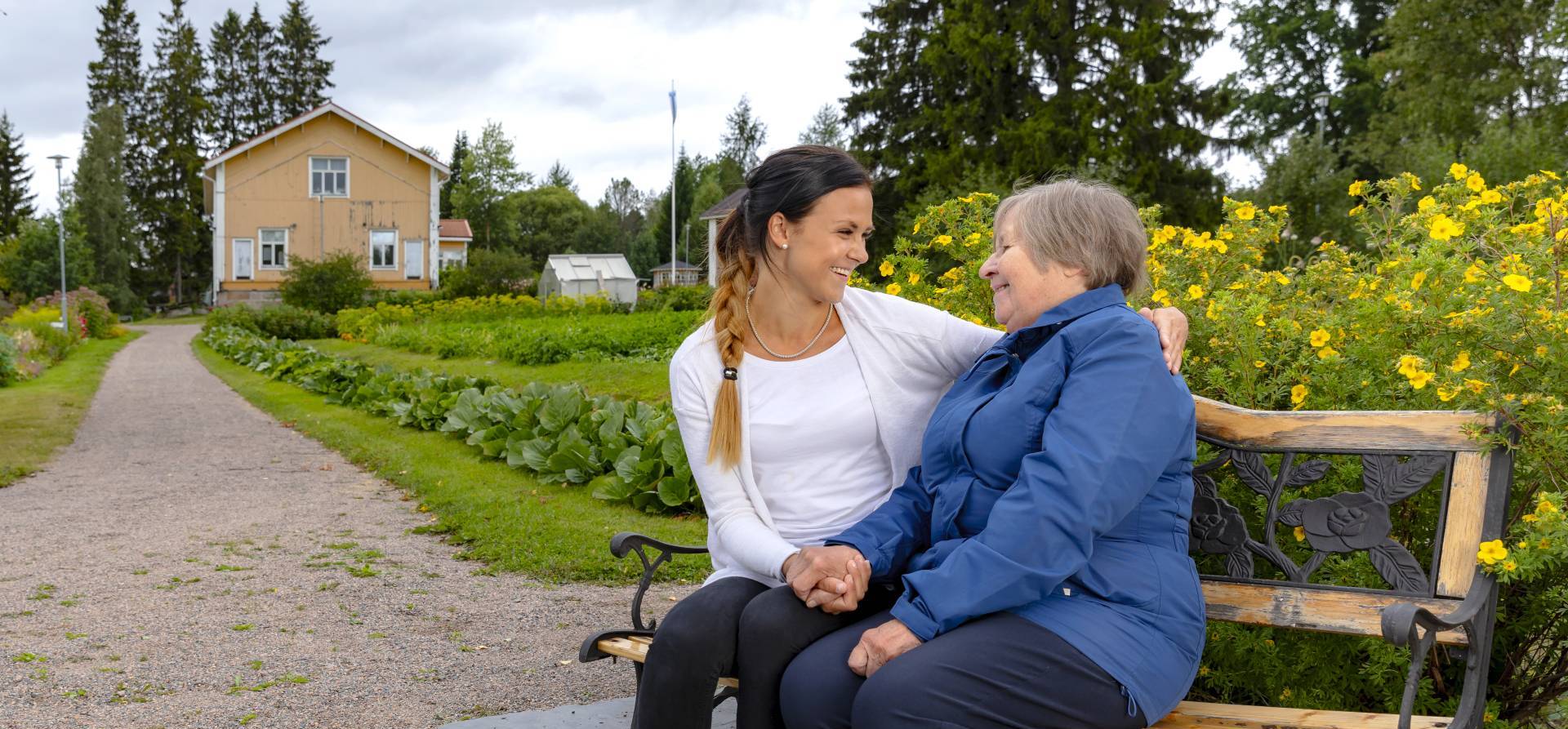 Kaksi eri-ikäistä naista puistonpenkillä.
